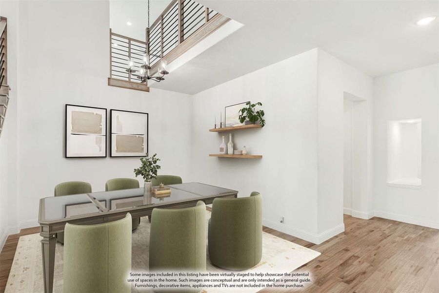 Dining room with two-story ceiling, wood floors, chandelier, and green upholstered chairs around a rectangular table