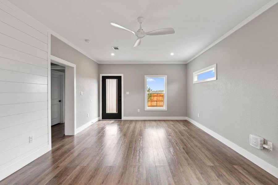 Entryway with wood finished floors, ceiling fan, and crown molding