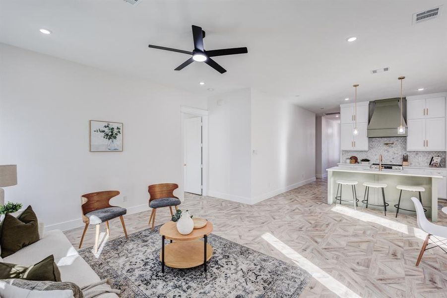 Living room featuring ceiling fan, sink, and light parquet floors