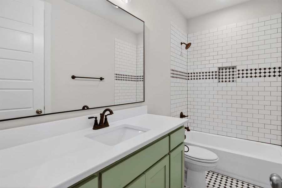 Bathroom featuring a single basin vanity with a light green base, white countertop, and dark-finished faucet Bathroom featuring a single basin vanity with a light green base, white countertop, and dark-finished faucet
