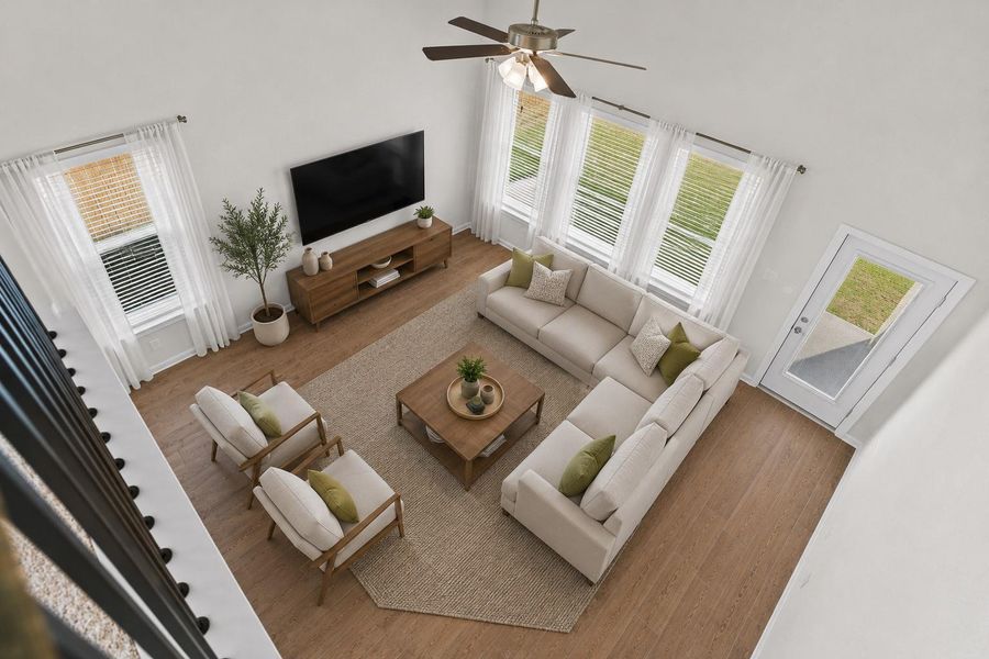 Stunning overhead view from the second floor showcasing the dramatic two story family room below. The beautiful wood looking tile flooring throughout the first floor adds warmth and elegance while the large windows and ceiling fan enhance the open and airy feel of the home. *Photo is Virtually Staged*
