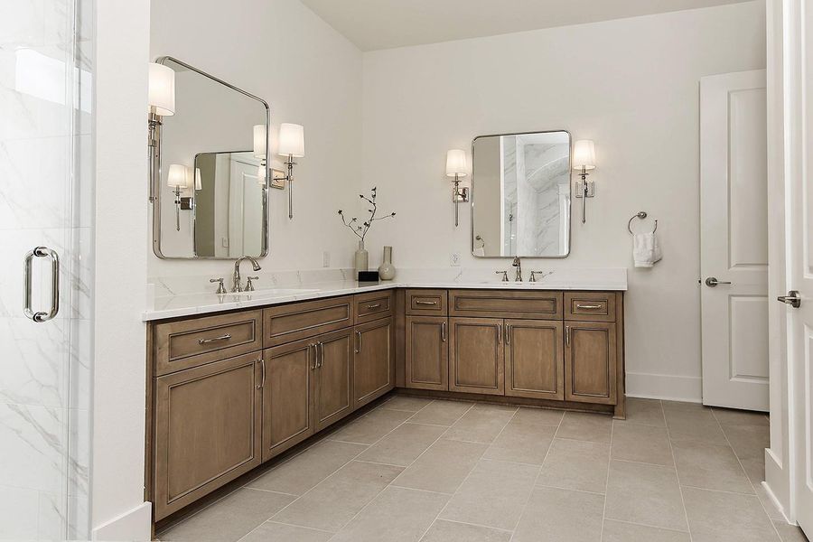 Gorgeous silver sconces flank impressive-sized mirrors, along with high end plumbing fixtures and cabinet pulls.