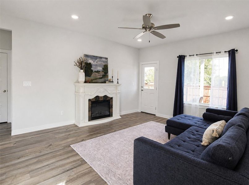 A classic ornamental fireplace anchors this inviting living space complete with handsome wood-look flooring. A classic ornamental fireplace anchors this inviting living space complete with handsome wood-look flooring.
