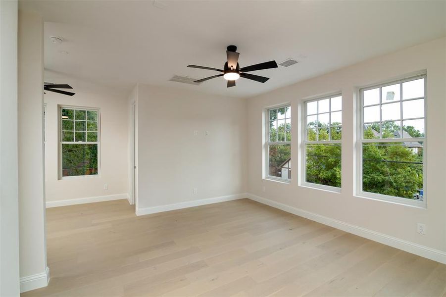 Unfurnished room with ceiling fan and light hardwood / wood-style flooring