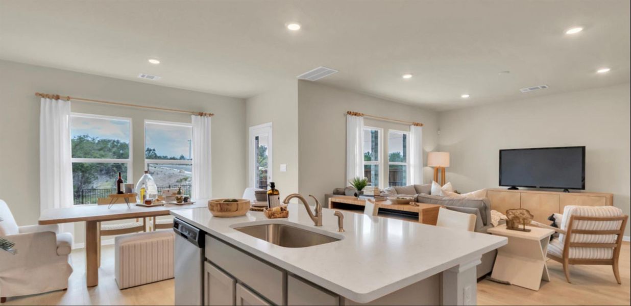 Kitchen featuring gray cabinetry, recessed lighting, a kitchen island with sink, open floor plan, and light wood-style flooring