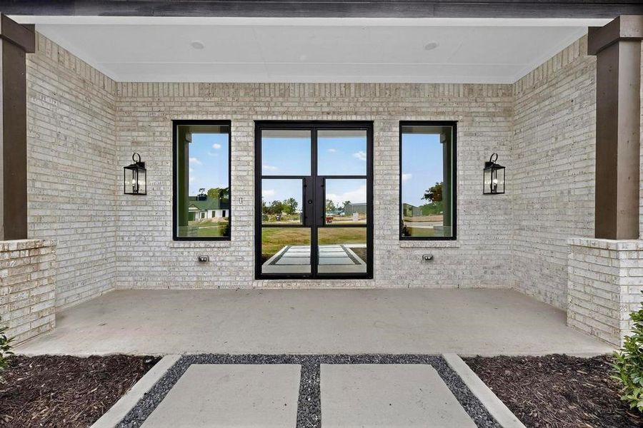Doorway to property with brick siding, a patio area, and french doors Doorway to property with brick siding, a patio area, and french doors