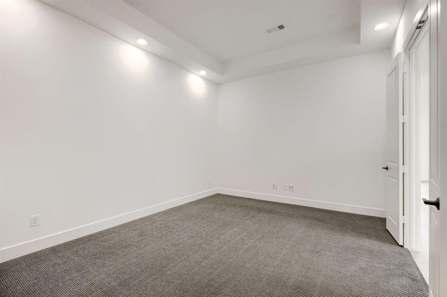 Spare room with recessed lighting, dark carpet, and a raised ceiling