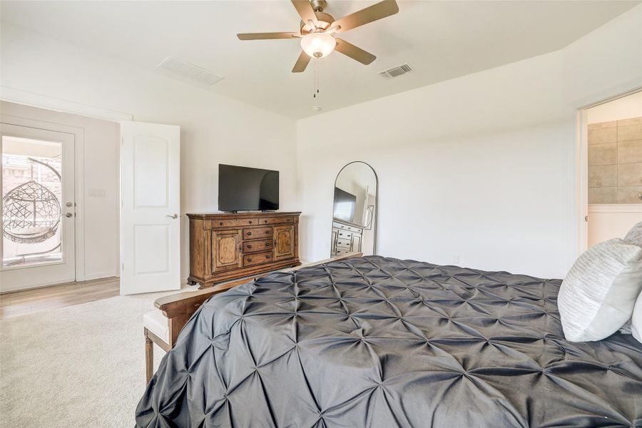 Carpeted bedroom with a ceiling fan and ensuite bathroom