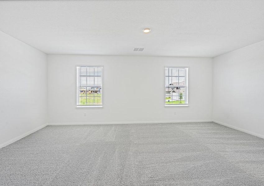 Master bedroom with two windows and lush carpet