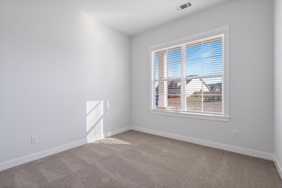 Neutral-toned carpeting, white walls, white window trim, and white horizontal blinds