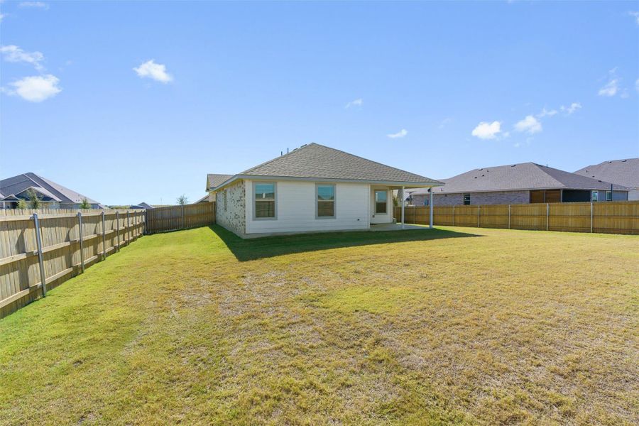 Back of house featuring a patio area, a fenced backyard, and a shingled roof
