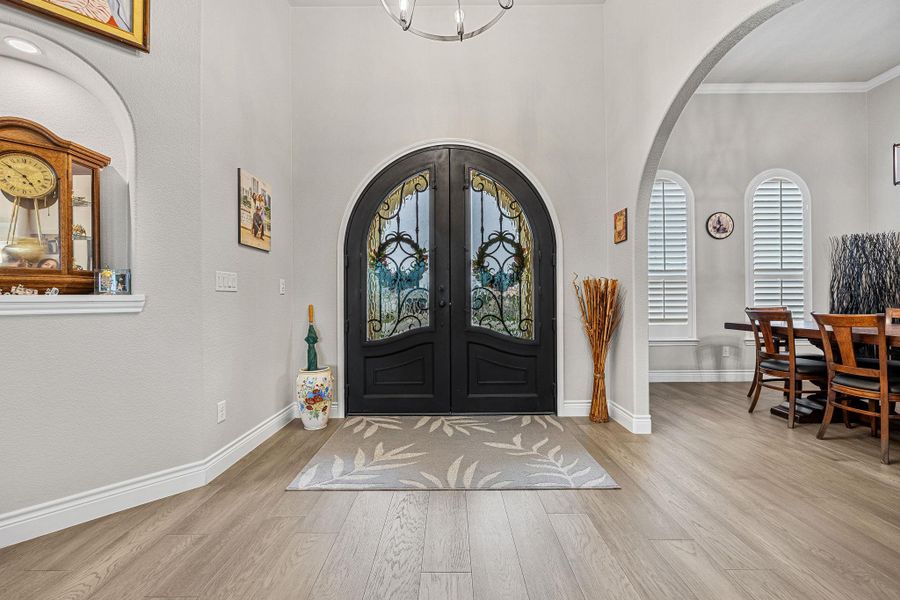 Enter through ornate double doors into a grand entryway with soaring ceilings and rich wood flooring. Enter through ornate double doors into a grand entryway with soaring ceilings and rich wood flooring.
