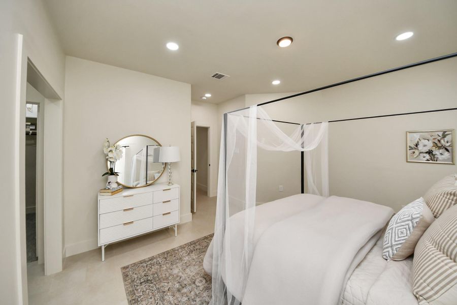 Step into the serene primary bedroom, featuring elegant decor and a peaceful ambiance.