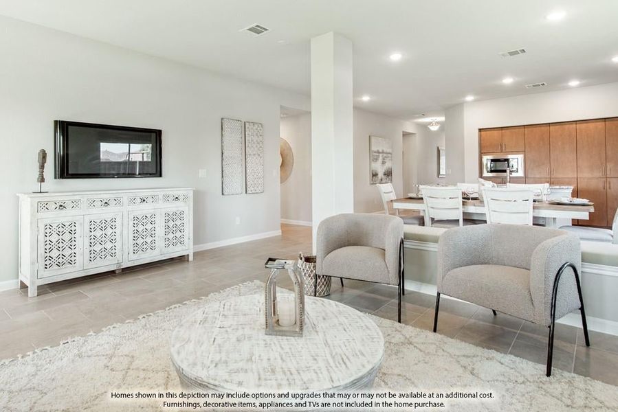 Open-concept living room with tile floors, wall-mounted TV, and dining area visible in background