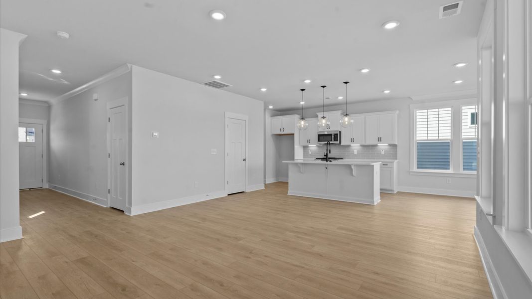 Spacious family room with rich hardwood flooring and elegant trim work in a reputable DRB Homes build