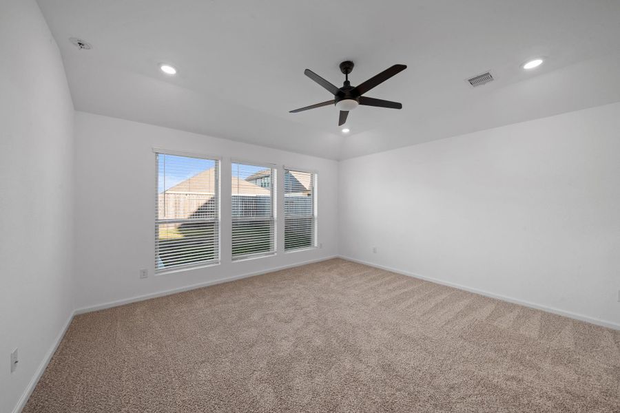 The spacious primary bedroom is designed to be a true retreat. Soft carpeting adds comfort underfoot, while three large windows fill the room with beautiful natural light throughout the day.