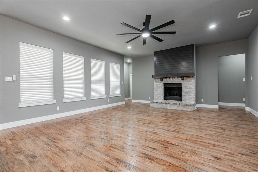 Unfurnished living room with baseboards, a ceiling fan, light wood-style flooring, and recessed lighting Unfurnished living room with baseboards, a ceiling fan, light wood-style flooring, and recessed lighting