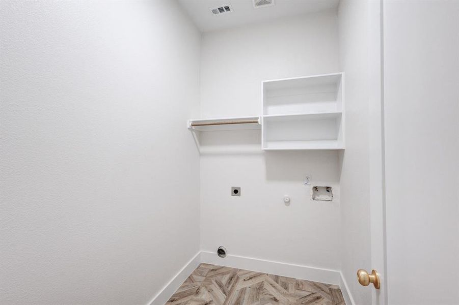 Washroom with hookup for an electric dryer, light parquet flooring, gas dryer hookup, and washer hookup