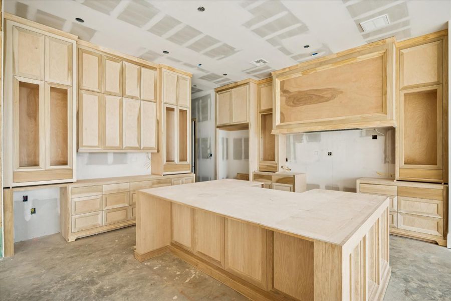 The kitchen takes shape with custom cabinetry and a large island built to receive premium countertops. The layout is planned for a full-height backsplash and undermount sinks, giving the space a refined, modern look. A chef-ready workspace designed to balance everyday function with elevated style.