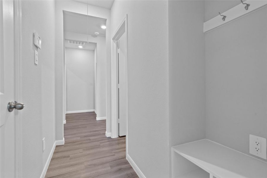 This dedicated area features a custom built-in bench with hooks, perfect for organizing coats, bags, and shoes right off the main hallway, keeping the rest of the home tidy. This dedicated area features a custom built-in bench with hooks, perfect for organizing coats, bags, and shoes right off the main hallway, keeping the rest of the home tidy.