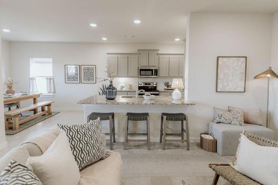 Kitchen with stainless steel appliances, light stone counters, recessed lighting, a kitchen breakfast bar, and a peninsula Kitchen with stainless steel appliances, light stone counters, recessed lighting, a kitchen breakfast bar, and a peninsula
