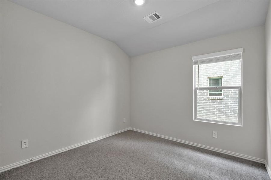 Empty room with carpet floors and vaulted ceiling Empty room with carpet floors and vaulted ceiling