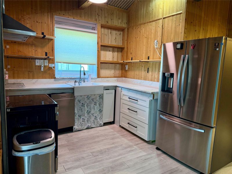 A well-equipped kitchen features natural wood paneling and sleek, modern appliances.