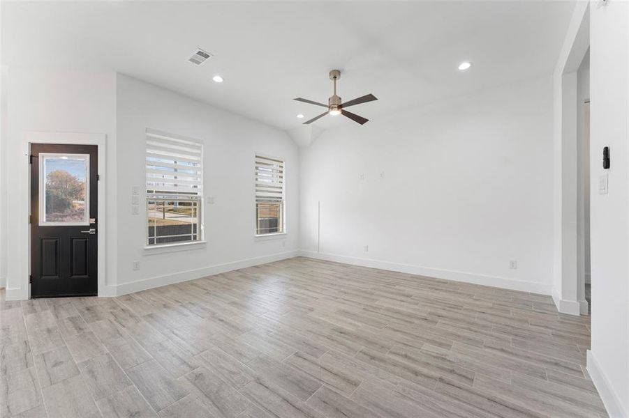 Unfurnished living room with ceiling fan and light hardwood / wood-style floors