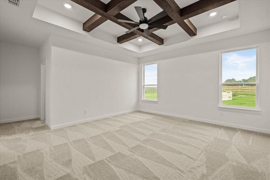 Empty room featuring beamed ceiling, light colored carpet, and coffered ceiling