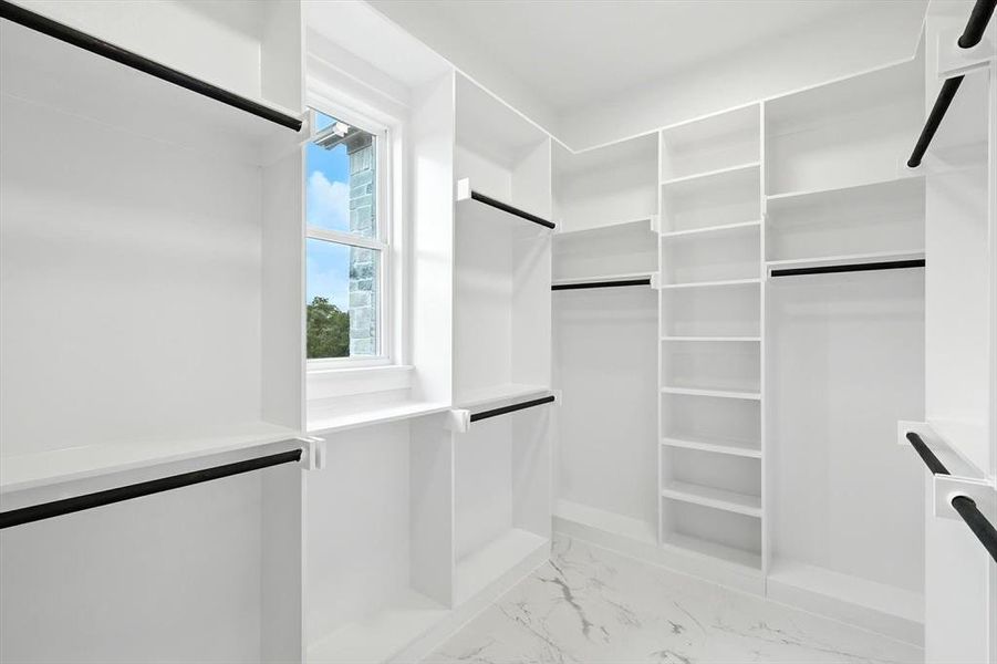 Spacious closet featuring light marble finish flooring