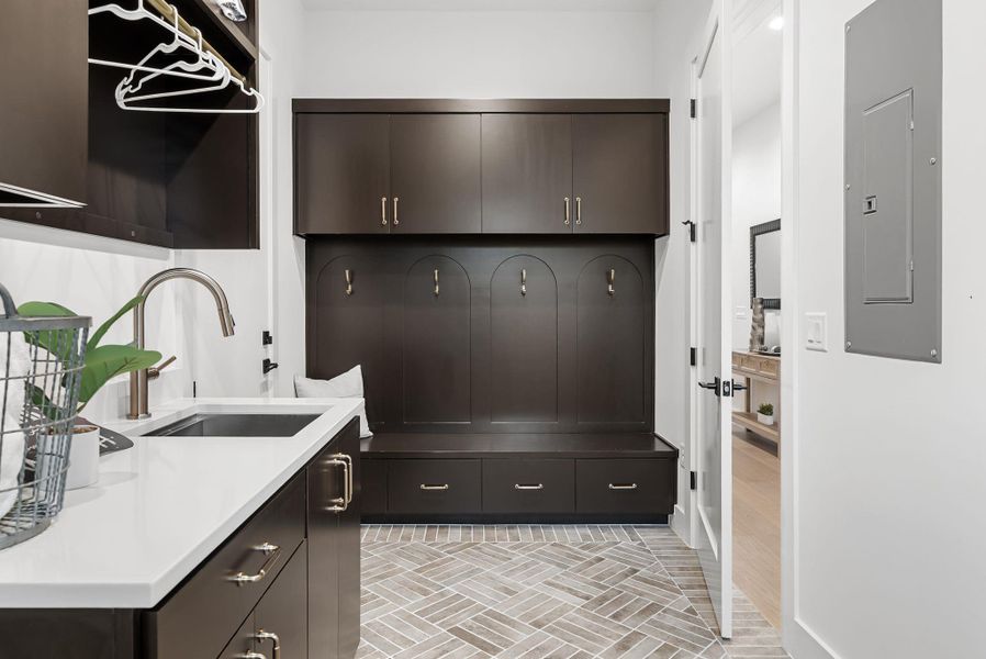Mudroom featuring a sink and electric panel