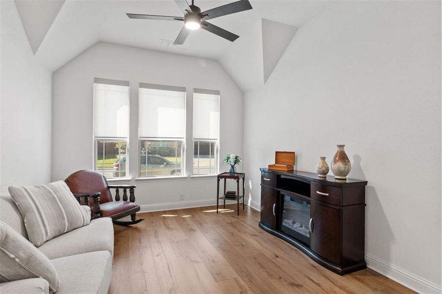 Sitting room with light wood finished floors, lofted ceiling, and ceiling fan