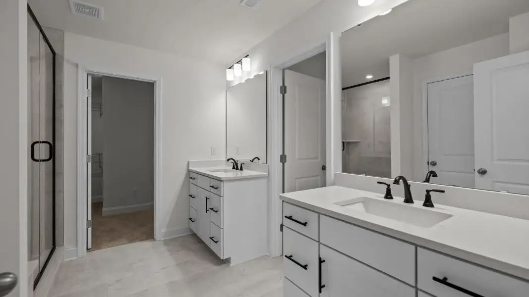 Norris Design primary bathroom with separate vanities and premium finishes. At Lakeside Glen by DRB Homes in York, SC. Norris Design primary bathroom with separate vanities and premium finishes. At Lakeside Glen by DRB Homes in York, SC.