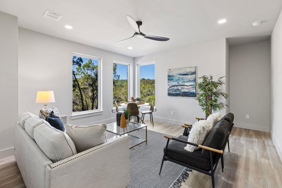 Living room featuring visible vents, light wood-style flooring, a ceiling fan, recessed lighting, and baseboards