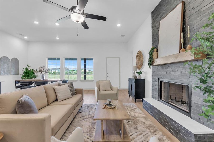 Living area featuring a fireplace, wood finished floors, recessed lighting, and a ceiling fan Living area featuring a fireplace, wood finished floors, recessed lighting, and a ceiling fan