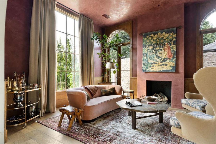 Sitting room with wainscoting, a premium fireplace, wood-type flooring, wood walls, and a decorative wall