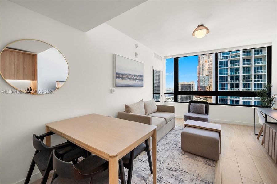 Floor-to-ceiling windows, wood-finish flooring, and recessed ceiling lighting