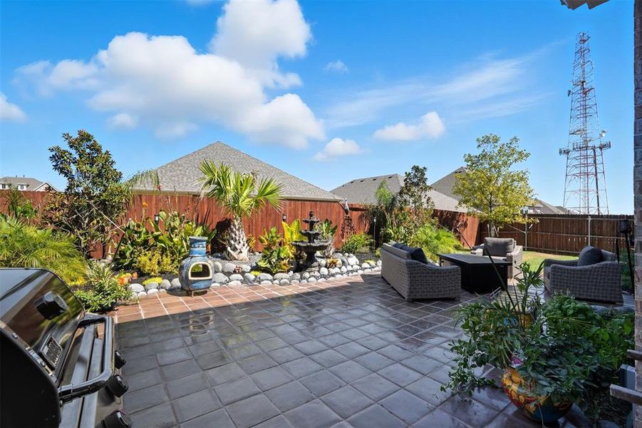 Fenced backyard with an outdoor hangout area, grilling area, and a patio Fenced backyard with an outdoor hangout area, grilling area, and a patio