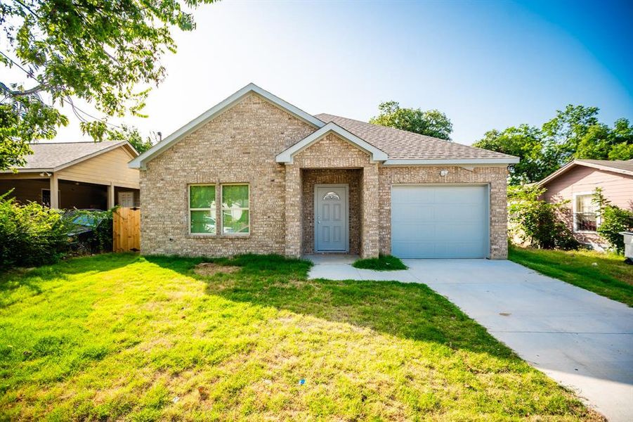 Ranch-style home featuring a garage and a front yard