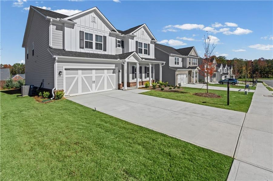 Front exterior of a new home in Berkeley Mill, Cumming, GA, highlighting curb appeal (Image 1). Front exterior of a new home in Berkeley Mill, Cumming, GA, highlighting curb appeal (Image 1).