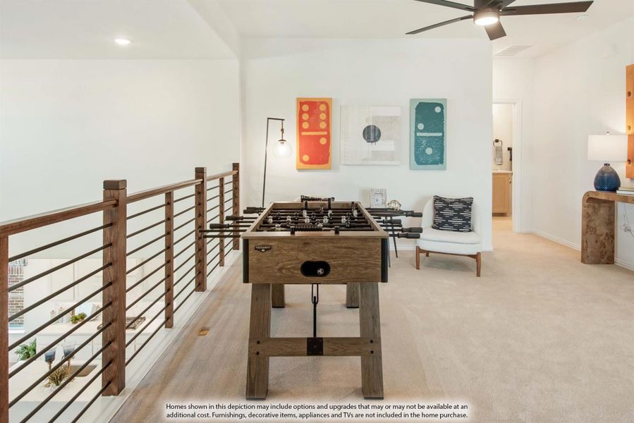 Open loft game room with foosball table, wood railing, ceiling fan, and carpet flooring