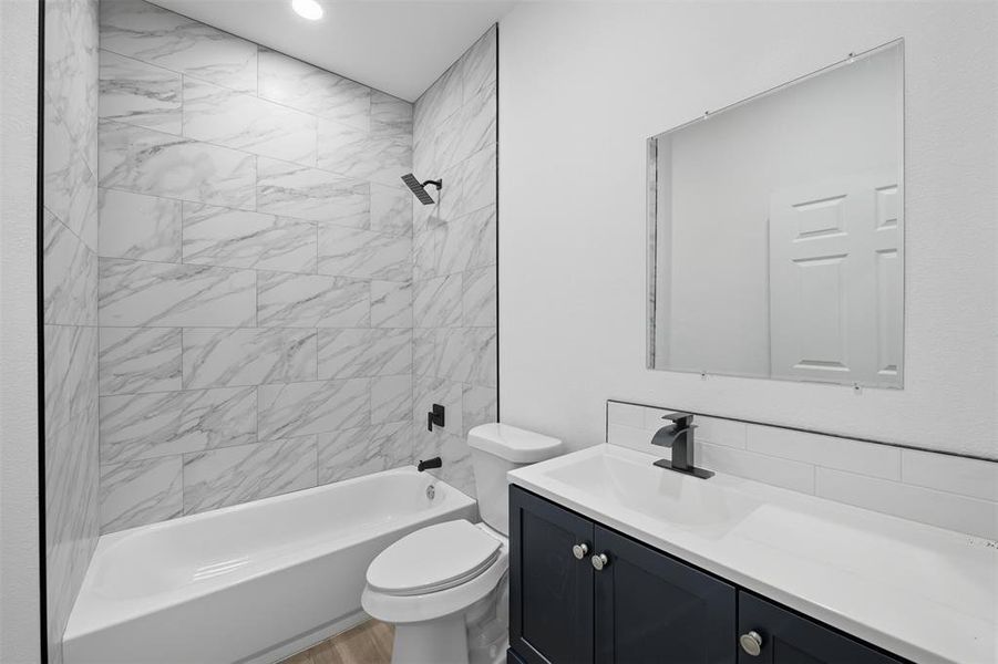 Bathroom with shower / bathtub combination, vanity, and light wood-style floors Bathroom with shower / bathtub combination, vanity, and light wood-style floors