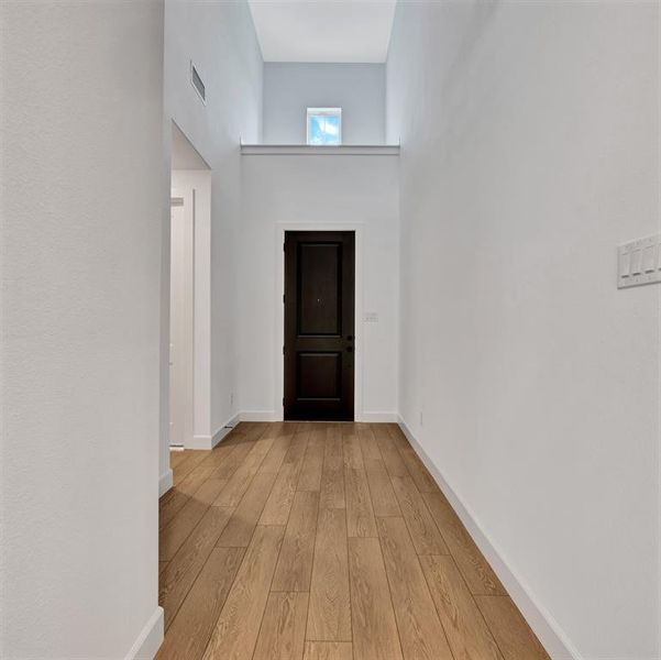 Entrance foyer featuring light hardwood / wood-style floors and a towering ceiling