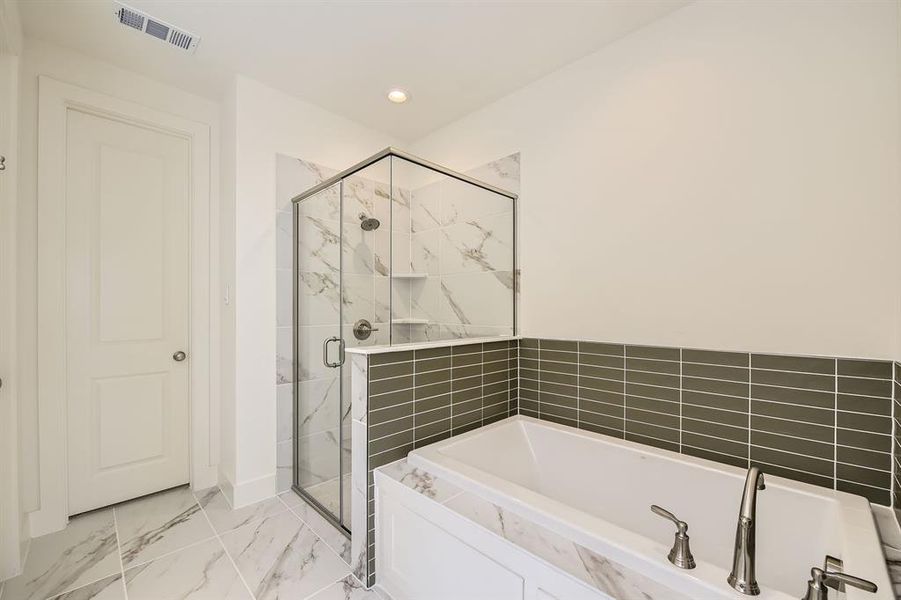 Full bathroom featuring visible vents, marble finish floor, a bath, and a shower stall