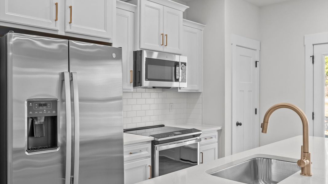 Highly skilled craftsmanship shines in this modern kitchen with pendant lighting and a central island focal point