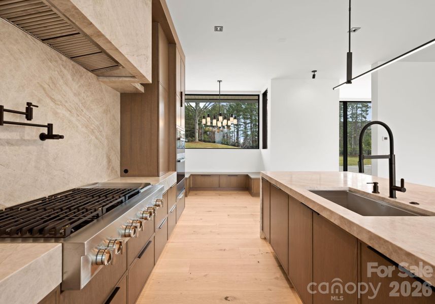 Kitchen featuring a waterfall island, custom cabinetry, and high-end appliances. Kitchen featuring a waterfall island, custom cabinetry, and high-end appliances.