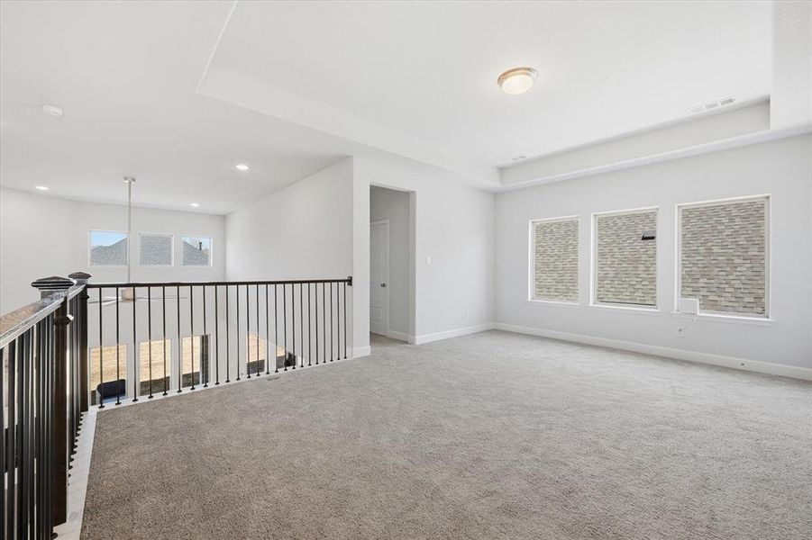 Living area on second floor with a balcony view of downstairs living room & kitchen
