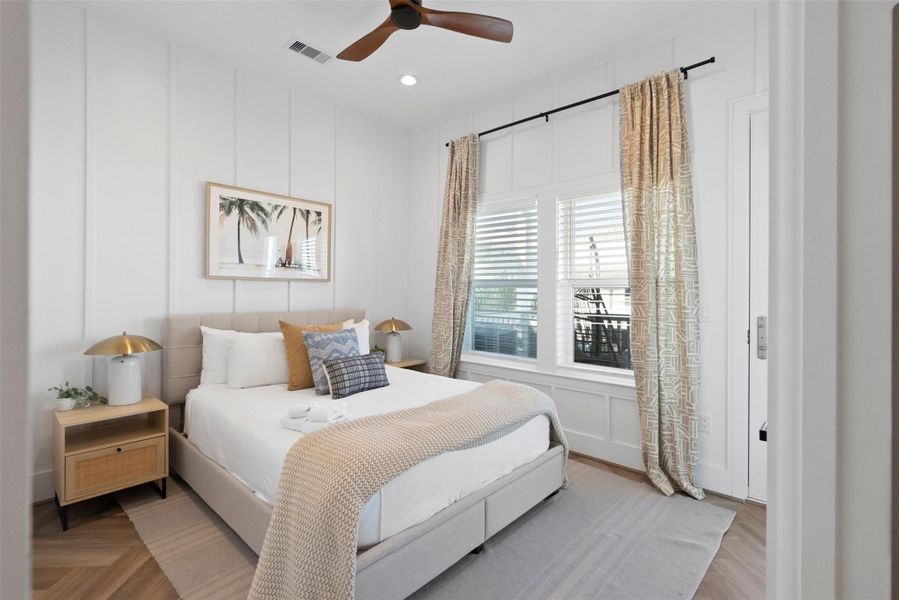 On the first floor, discover a serene secondary bedroom designed with understated elegance. Bathed in natural light, this bright retreat features a soothing neutral palette, a sleek bedside setup, and a rich wood-toned ceiling fan—offering effortless comfort and a breezy coastal charm that feels like a private getaway. On the first floor, discover a serene secondary bedroom designed with understated elegance. Bathed in natural light, this bright retreat features a soothing neutral palette, a sleek bedside setup, and a rich wood-toned ceiling fan—offering effortless comfort and a breezy coastal charm that feels like a private getaway.