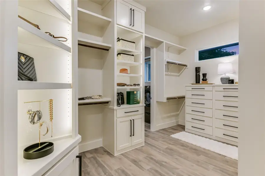 Walk in closet featuring custom built-in storage Walk in closet featuring custom built-in storage