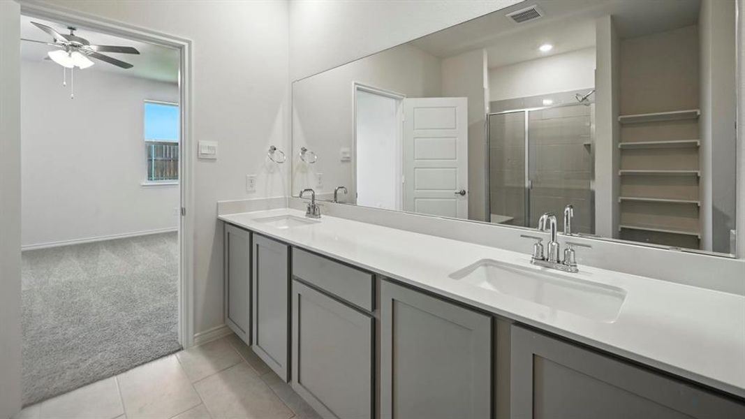 Double vanity featuring light grey cabinetry, white countertops, and chrome fixtures